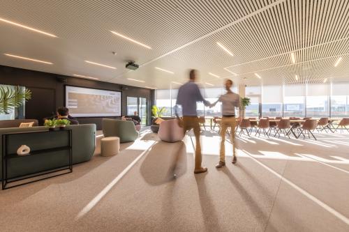 Moderne kantoorruimte te huur in Aalst met comfortabele zitplaatsen en zakelijke professionals die overleggen. Licht interieur en ruime opstelling aan de Korte Keppestraat 19 voor een inspirerende werkomgeving.