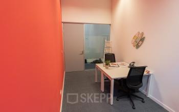 Zakelijke ruimte te huur in Antwerpen Berchem, Uitbreidingstraat 84, met twee werkplekken en kleurrijke decoratie.