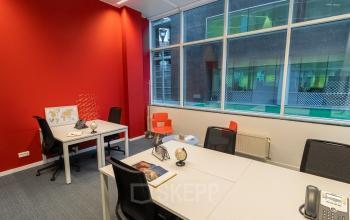 Kantoorruimte te huur aan de Uitbreidingstraat 84, Antwerpen Berchem. Kantoor met moderne inrichting en werkplekken bij het raam.