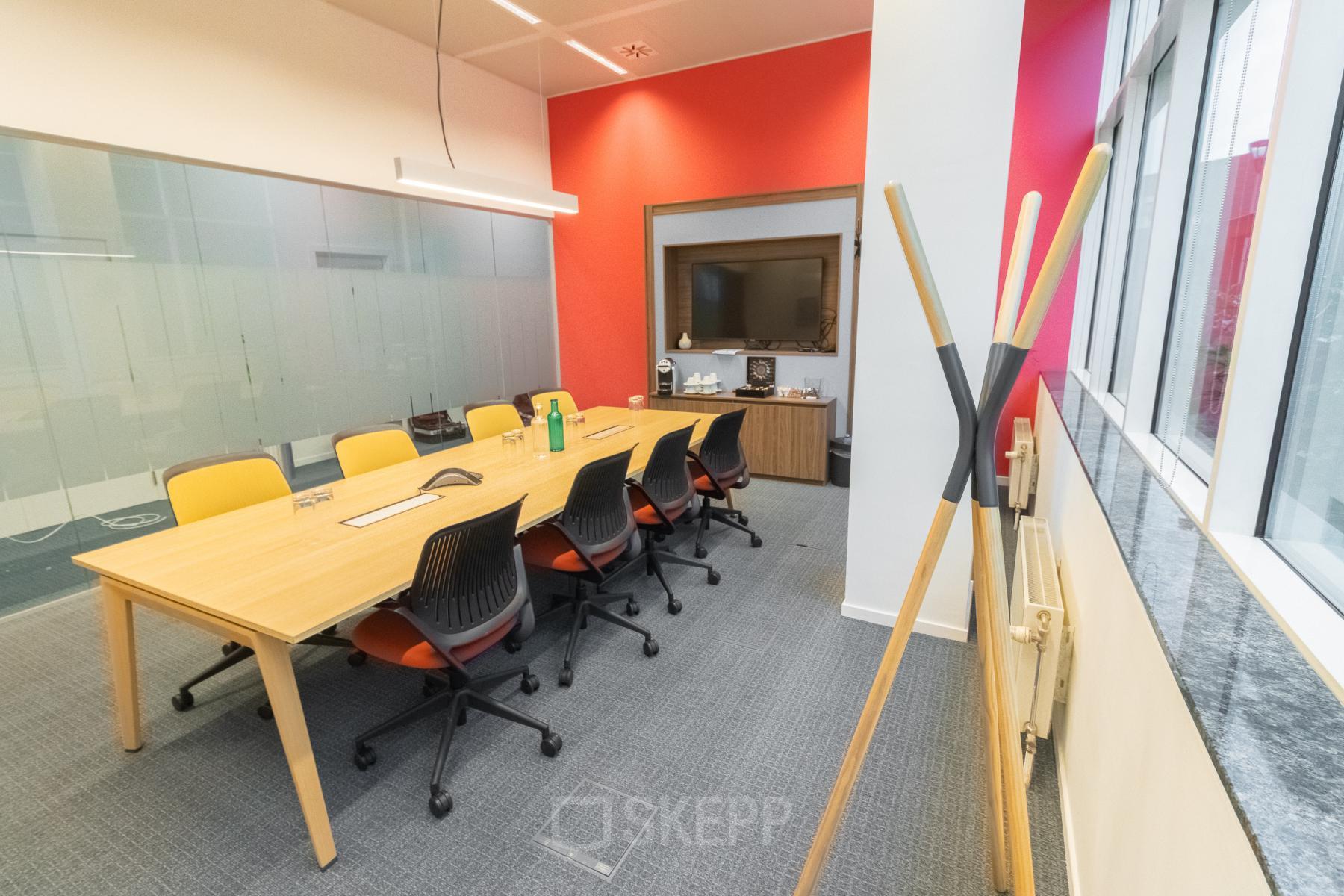 Vergaderruimte te huur in Antwerpen Berchem aan de Uitbreidingstraat 84 met lichte muren, lange houten tafel, comfortabele stoelen en moderne audiovisuele apparatuur.