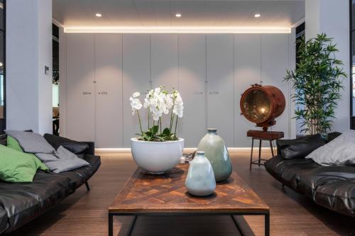 Lounge ruimte van het kantoor te huur op Uitbreidingstraat 66, Antwerpen Berchem met moderne zithoek, planten en decoratieve objecten.