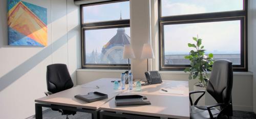Modern kantoor te huur op De Keyserlei 58-60 in Antwerpen Centrum, met twee bureaus, comfortabele stoelen en een prachtig uitzicht op de stad.