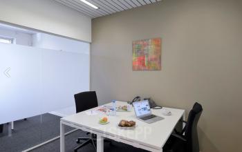 Moderne kantoorruimte te huur in Antwerpen Centrum, gelegen aan de Lange Lozanastraat 142, met twee bureaus, stoelen en een laptop op tafel. Ideaal om direct aan het werk te gaan.