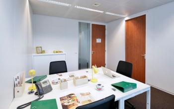 Functionele kantoorruimte te huur met witte tafels, zwarte stoelen en moderne inrichting in Antwerpen Centrum, Lange Lozanastraat 142. Geschikt voor je volgende zakelijk avontuur.