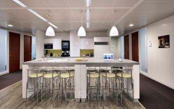 Moderne gemeubileerde kantoorruimte te huur op Lange Lozanastraat 142 in Antwerpen Centrum met een ruime tafel en stoelen, perfect voor informele vergaderingen of pauzes.