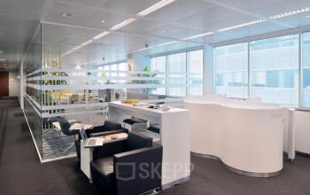 Modern ingerichte kantoorruimte te huur op Lange Lozanastraat 142, Antwerpen Centrum, met comfortabele zwarte stoelen en een glazen wand voor verlichting.