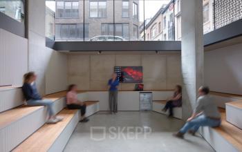 Kantoorruimte te huur op Lange Winkelhaakstraat 26 in Antwerpen Centrum, met moderne inrichting en personen in bespreking.