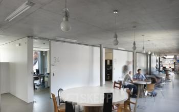 Kantoorruimte te huur op Lange Winkelhaakstraat 26, Antwerpen Centrum, met moderne tafels en stoelen waar mensen vergaderen.