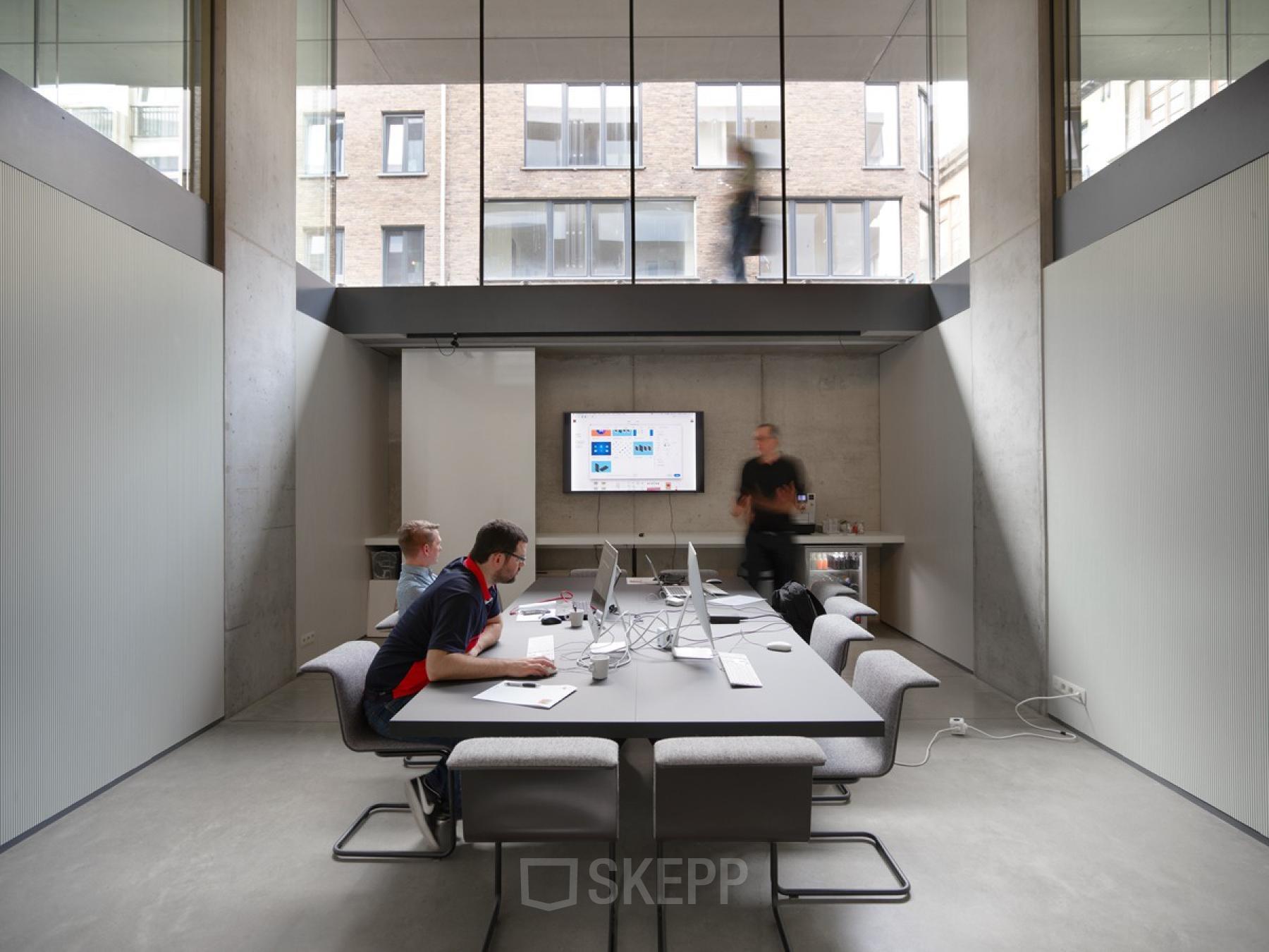 Vergaderruimte in modern kantoor te huur op Lange Winkelhaakstraat 26, Antwerpen Centrum met kantoormedewerkers aan het werk rondom een grote tafel.