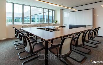 Vergaderruimte van kantoor te huur in Antwerpen Wommelgem, Nijverheidsstraat 70, met grote tafel, comfortabele stoelen en een projector.