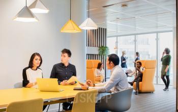 Zakelijke bijeenkomst in moderne kantoorruimte te huur aan Leonardo Da Vincilaan 1, Brussel Airport, Brussel. Verschillende mensen aan het werk en overleggend in lichte, ruimtelijke omgeving.