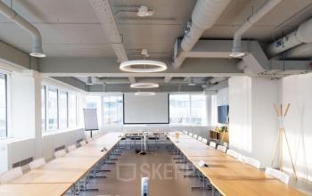 Heldere vergaderruimte op Pegasuslaan 5, Brussel Airport, met moderne lange tafels en audiovisuele presentatievoorzieningen, ideaal voor kantoorruimte te huur.