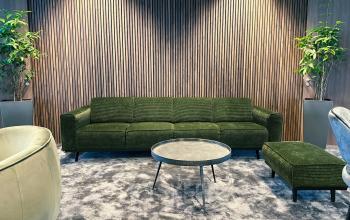 Gezellige zithoek met groene sofa, voetenbank, ronde tafel en planten, kantoor te huur op Leonardo Da Vincilaan 19, Brussel Airport.