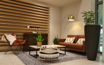 Gezellige lobby van Leonardo Da Vincilaan 19 met zithoek, planten en moderne inrichting bij Brussel Airport; kantoorruimte te huur.