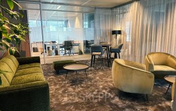 Moderne kantoorruimte te huur op Leonardo Da Vincilaan 19 in Brussel Airport, met stijlvolle zitjes en grote ramen naar andere werkruimtes.