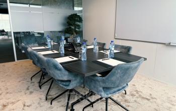 Vergaderruimte te huur in Brussel Airport, Leonardo Da Vincilaan 19, met moderne meubels en vergadertafel, compleet met waterflessen en notitieblokken.