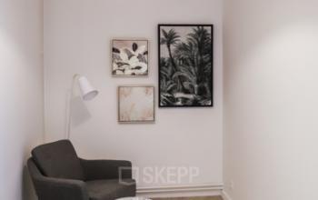 Gezellige klein kantoorruimte te huur op Rue du Congres 37 in Brussel met twee comfortabele stoelen, een bijzettafeltje en muurdecoraties.