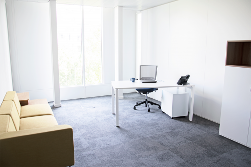 Kantoor te huur op Louizalaan 143, Brussel Elsene met ruime werkplek, groot raam en moderne meubels.