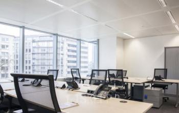 Licht en modern kantoor te huur op Louizalaan in Brussel Elsene, voorzien van ruime werkplekken met bureaus en stoelen, ideaal voor kantoorruimte huren met uitzicht op de stad.