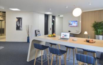 Moderne kantoorruimte te huur op Louizalaan, Brussel Elsene, met een ruime gemeubileerde werkplek inclusief laptop en tv. Ontspannende omgeving met eetbare decoraties en comfortabele zithoek.