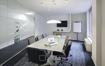 Vergaderruimte met glazen wanden en moderne voorzieningen op Louizalaan 65, Brussel Elsene. Stijlvol ingericht, perfect voor wie kantoorruimte wil huren. Ruime tafel met stoelen, klaar voor gebruik.