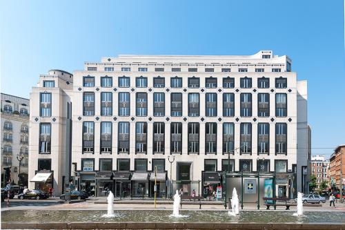 Kantoor te huur aan de Louizalaan 65 in Brussel Elsene, omringd door winkels en tegenover een levendig plein met fonteinen.