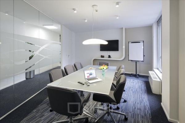 Vergaderruimte met glazen wanden en moderne voorzieningen op Louizalaan 65, Brussel Elsene. Stijlvol ingericht, perfect voor wie kantoorruimte wil huren. Ruime tafel met stoelen, klaar voor gebruik.