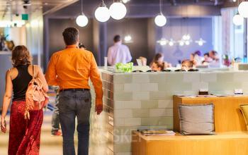 Gezellige kantoorruimte met een moderne uitstraling op Louizalaan/Avenue Louise 523, Brussel Elsene. Mensen overleggen aan tafels. Kantoorruimte te huur met een unieke sfeer.