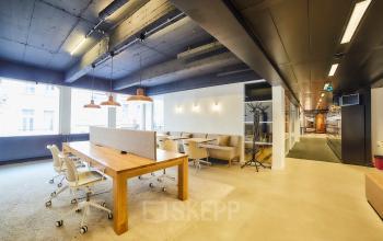 Modern kantoor te huur met houten tafels, comfortabele stoelen en gezellige verlichting in Brussel Elsene op Louizalaan / Avenue Louise 523.