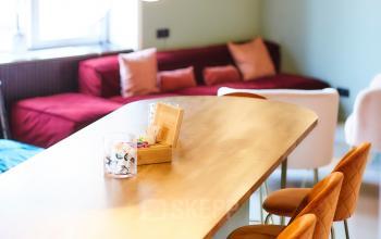 Sfeervolle kantoorruimte te huur op Louizalaan / Avenue Louise 54 in Brussel Elsene met een lange tafel, comfortabele stoelen en hanglampen.