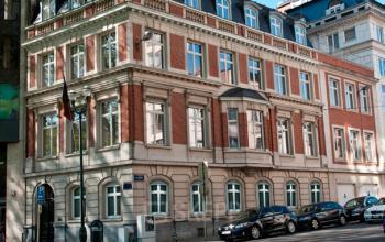 Klassiek kantoorpand te huur aan de Louizalaan / Avenue Louise 367 in Brussel Elsene, met rood baksteen en witte ornamenten. Diverse auto's geparkeerd aan de straat.