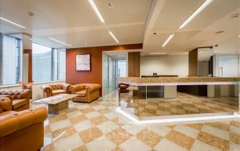 Chique kantoorruimte te huur in Brussel Etterbeek aan het Schumanplein, compleet met lederen fauteuils, een moderne receptie en grote ramen voor natuurlijk licht. Ideaal voor zakelijke ontmoetingen.