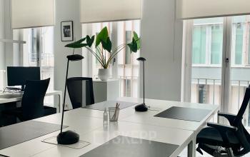 Modern ingericht kantoor te huur op Rue d'Arlon 25, Brussel Europese Wijk. Grote ramen voor veel lichtinval, met bureaus en ergonomische stoelen.