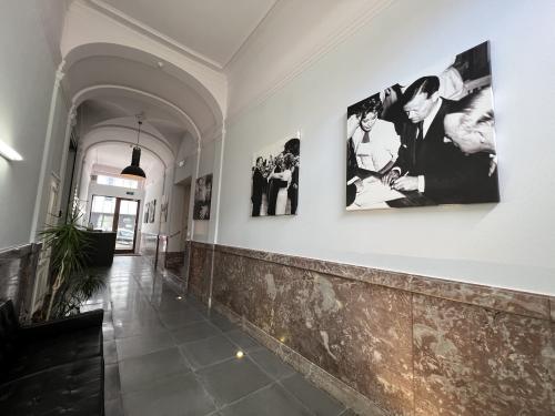 Ingang van een kantoorpand op Rue d’Arlon 25, Brussel Europese Wijk, met kunstwerken aan de muur en een zwarte sofa.