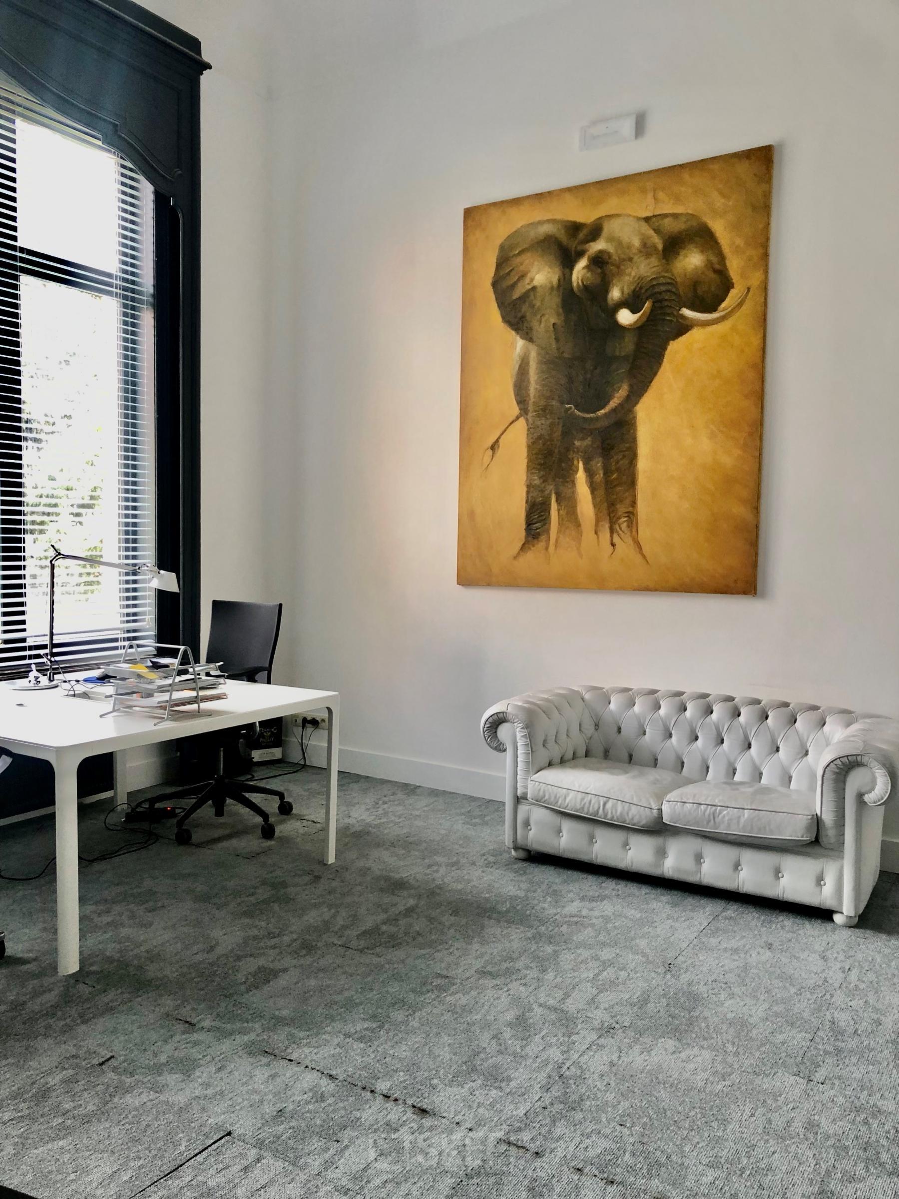 Kantoorruimte te huur op Rue d’Arlon 25 in Brussel Europese Wijk, modern ingericht met een bureau, zwarte stoel en witte sofa, verlicht door natuurlijk licht.