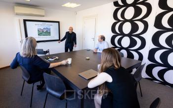 Vergaderruimte in een kantoor te huur aan Avenue Palmerston 3, Brussel Europese Wijk; personen bezig met een zakelijke bespreking rond een grote tafel.