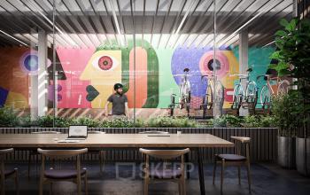 Fraaie kantoorruimte te huur op Avenue Louise 149 in Brussel, Europese Wijk. Moderne vergaderruimte met kleurrijke muurschilderingen en fietsenstalling op achtergrond, waar een individu bezig is met zakelijke taken.