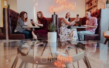 Een levendige coworking ruimte in Brussel, gelegen aan Robert Schumanplein 2-4, met mensen die samenwerken en gebruik maken van de kantoorruimte te huur.