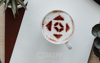 Bureau met koffiekopje en plant op een houten tafel in een kantoorruimte te huur aan het Robert Schumanplein in Brussel Europese Wijk.