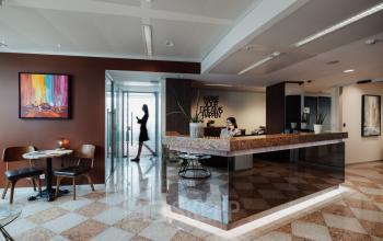 Moderne receptieruimte op Robert Schumanplein 2-4, Brussel Europese Wijk, met een stijlvolle balie en kunst aan de muren. Gezellige hoek met zitruimte.