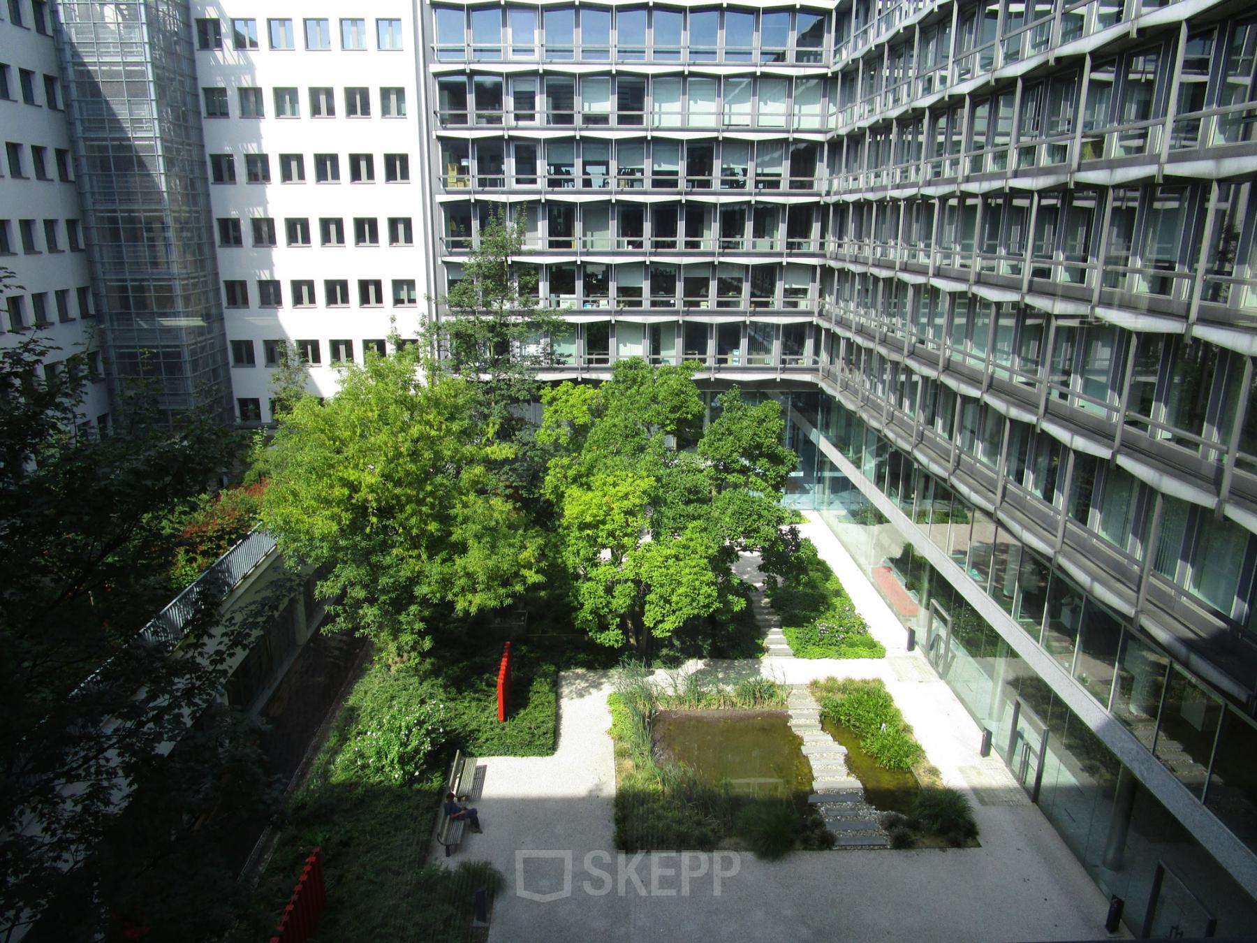 Binnenplaats van kantoor te huur op Kunstlaan / Avenue des Arts 56 in Brussel Europese Wijk, met veel groen en omliggende kantoorruimtes.