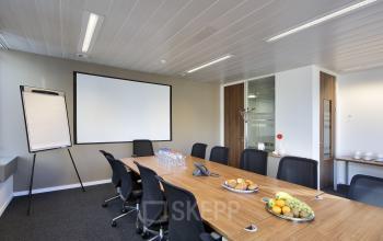Functionele kantoorruimte te huur in Brussel Zuid op Place Marcel Broodthaers 8, met een grote vergadertafel, comfortabele stoelen en audiovisuele apparatuur, ideaal voor zakelijke bijeenkomsten.