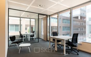 Kantoorruimte te huur aan Gaston Crommenlaan 8 in Gent Ledeberg, met moderne glazen wanden en praktische bureaus.