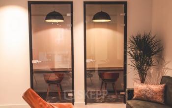 Kantoorruimte te huur op Oktrooiplein 1, Gent met moderne inrichting, glazen wanden, stijlvolle verlichting, en comfortabele zitplaatsen. Ideaal voor zakelijke activiteiten.