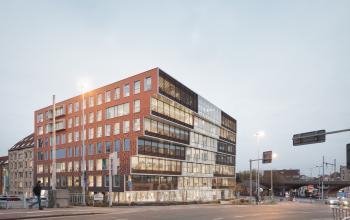 Modern kantoorgebouw aan Oktrooiplein 1, Gent, met grote ramen en een eigentijdse gevel. Kantoorruimte te huur in een levendige zakelijke omgeving.