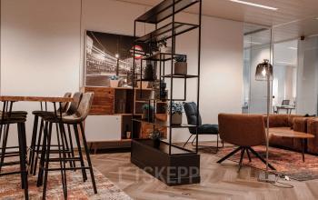 Moderne kantoorruimte te huur met stijlvolle inrichting, inclusief hoge tafels, comfortabele stoelen en een open werkruimte in Gent, Oktrooiplein 1.