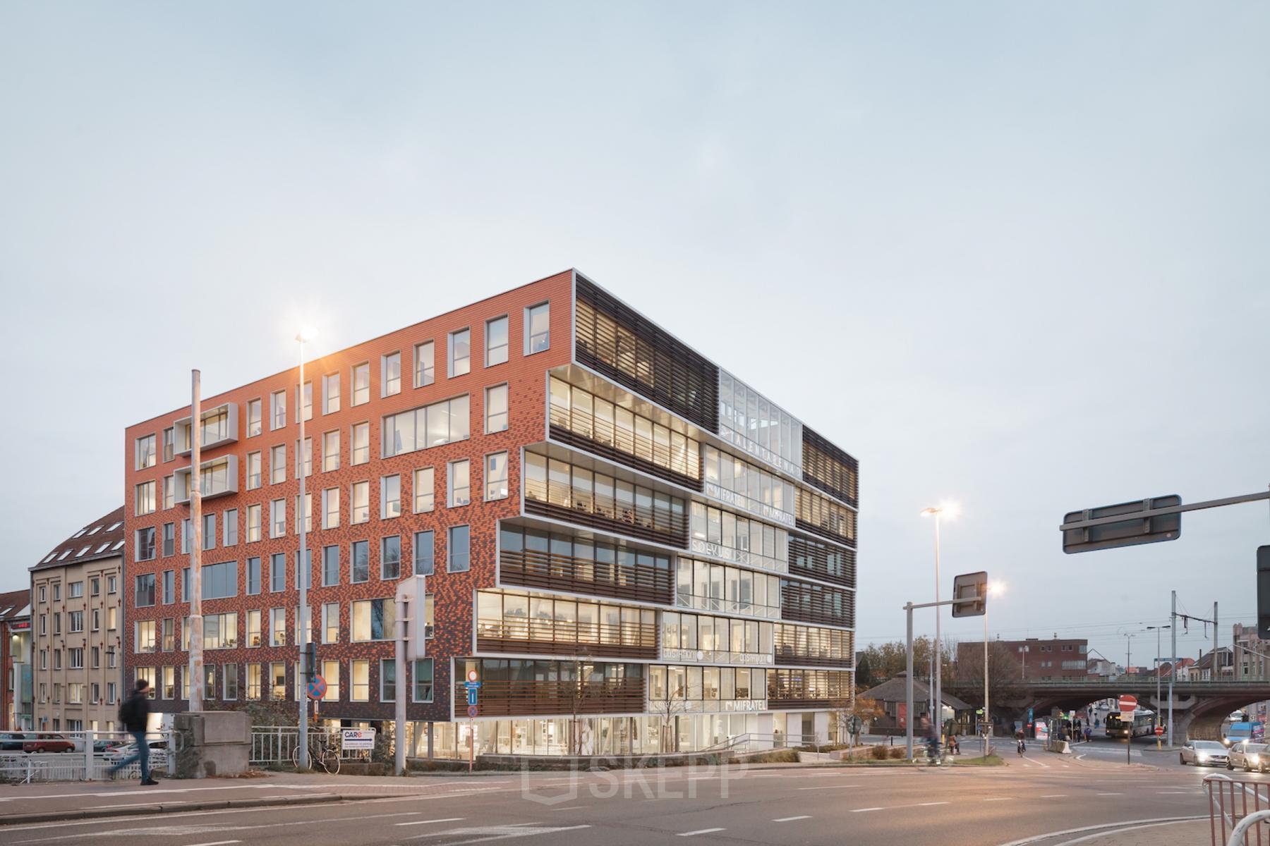 Modern kantoorgebouw aan Oktrooiplein 1, Gent, met grote ramen en een eigentijdse gevel. Kantoorruimte te huur in een levendige zakelijke omgeving.