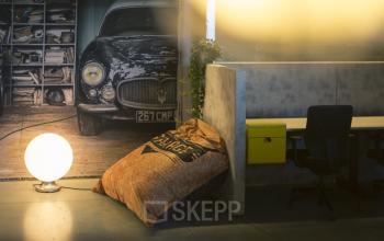 Sfeervolle kantoorruimte te huur op Diamantstraat 8, Herentals, met industriële look en uitnodigende zitgelegenheid naast een warme sfeerlamp.