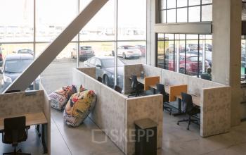 Moderne, open kantoorruimte met werkplekken en uitzicht op de parkeerplaats, ideaal voor wie kantoorruimte te huur zoekt op Diamantstraat 8, Herentals.