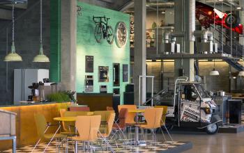 Kantoorruimte te huur met kleurrijke stoelen en bijzondere decoraties op de wand, ideaal voor creatieve werkruimtes. Gelegen op Diamantstraat 8 in Herentals, biedt het ruimte voor zakelijke bijeenkomsten.